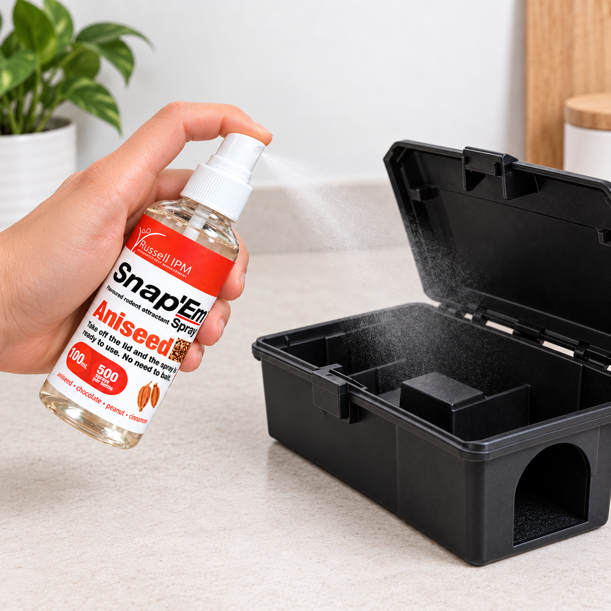 Snap’Em Anis Lockstoffspray für Ratten und Mäuse wird in eine geöffnete Köderstation gesprüht – Anwendung des 100-ml-Nagerlockstoffs.